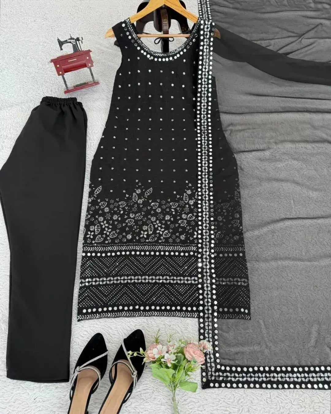 Black and white patterned dress with matching pants on a bed