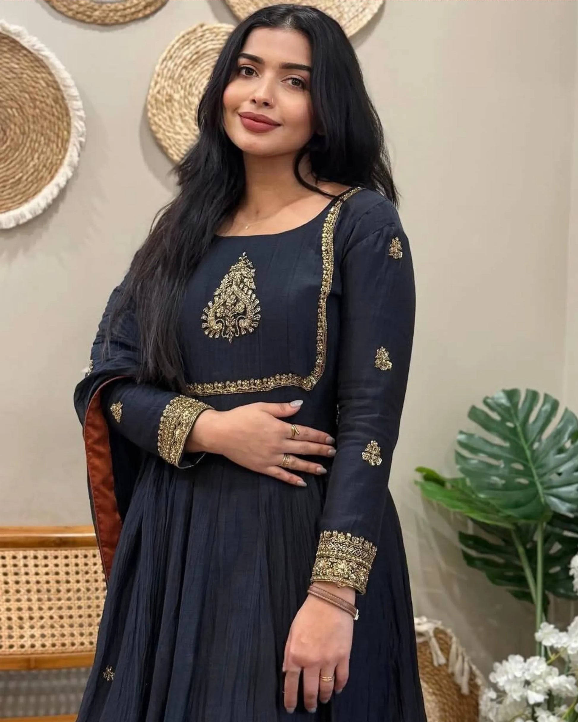 Woman wearing a black traditional outfit with gold embroidery