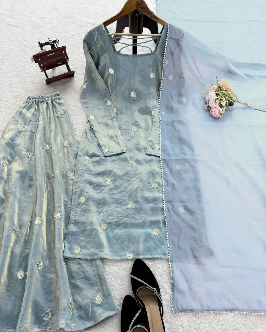 Light blue embroidered outfit with a hanger on a white background