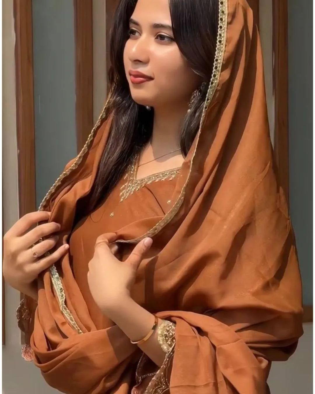 Woman wearing a brown suit with gold details