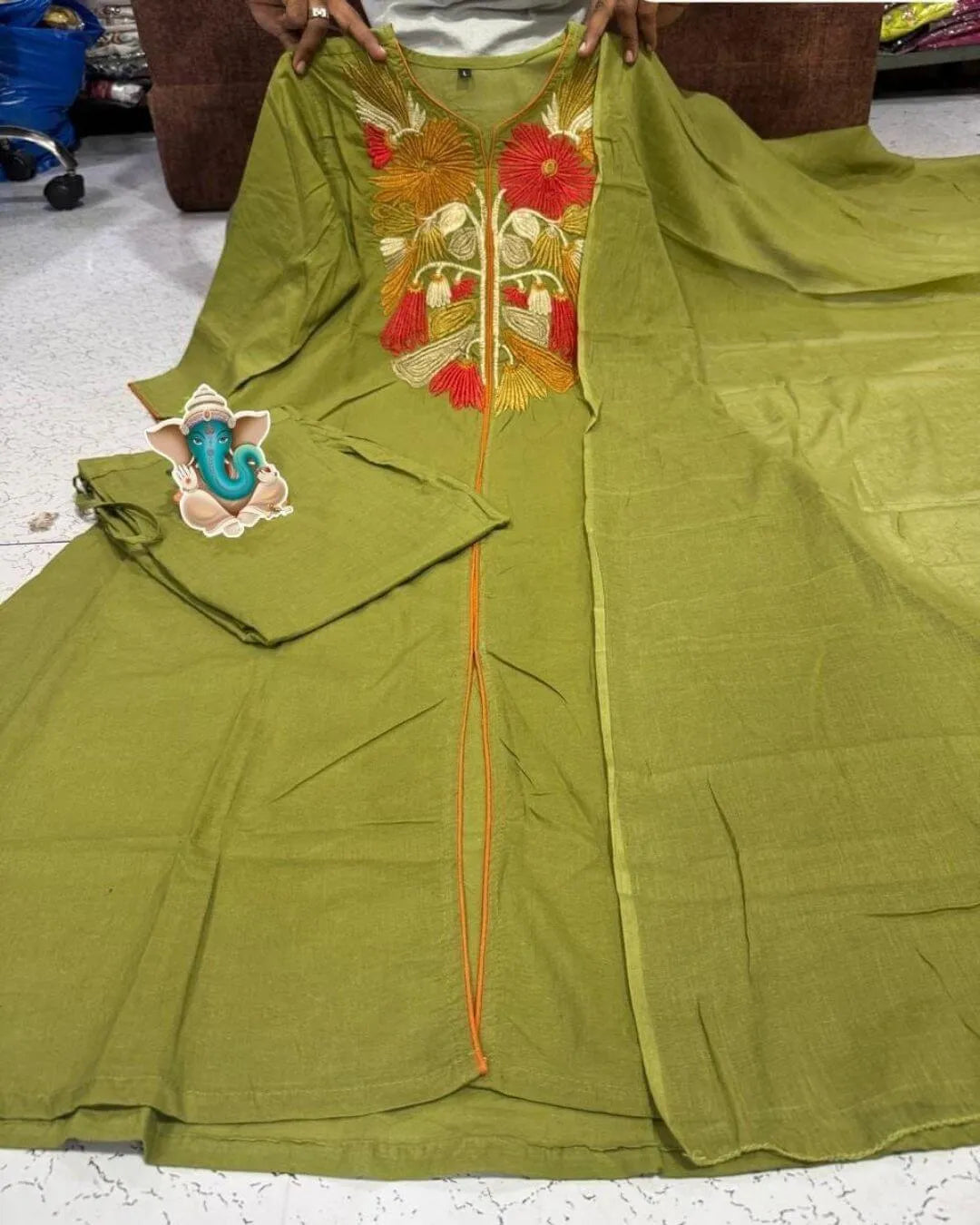 Woman wearing a Floral Printed Green Cotton Suit Set traditional outfit with floral patterns on a beige background
