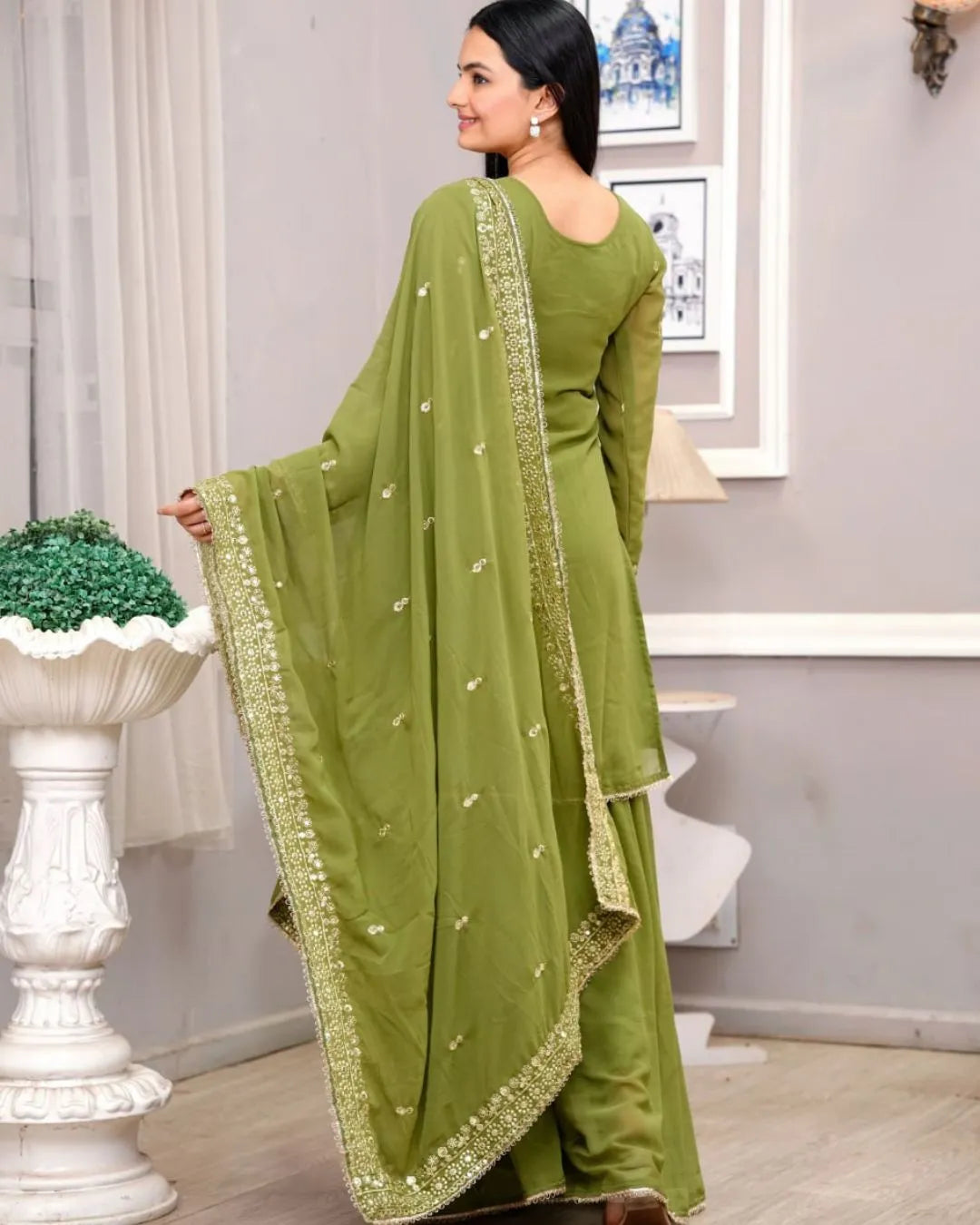 Woman wearing a green saree with a white background