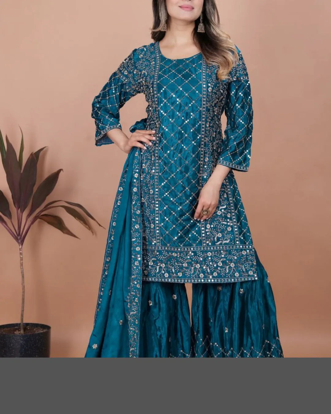 Teal embroidered traditional outfit with a plain background
