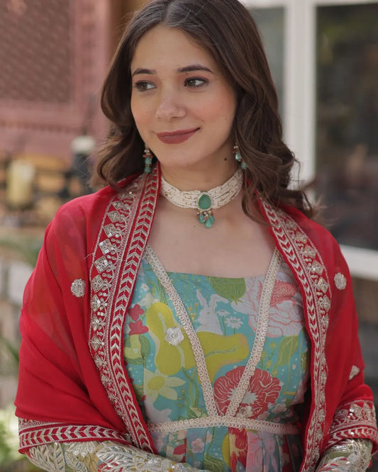 Woman wearing a colorful traditional outfit with a red shawl in an outdoor setting