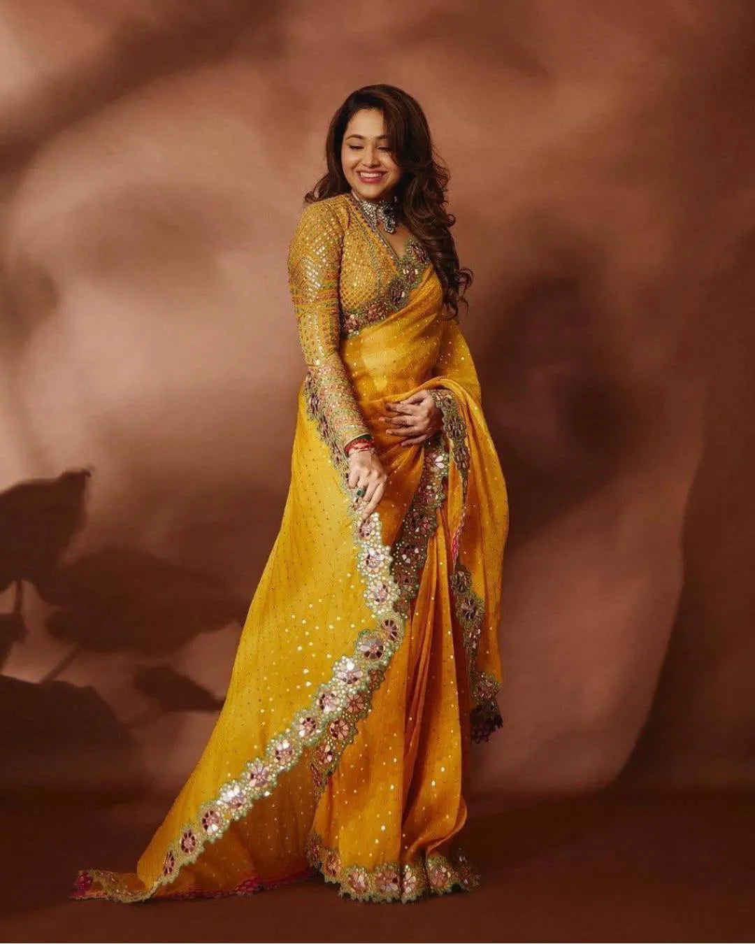 Woman in a yellow saree with intricate designs