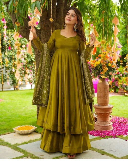 Woman in a green chiffon suit traditional outfit standing in a decorated garden.