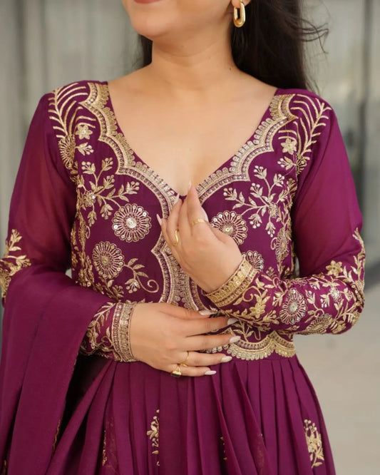 Purple traditional outfit with gold embroidery on a neutral background
