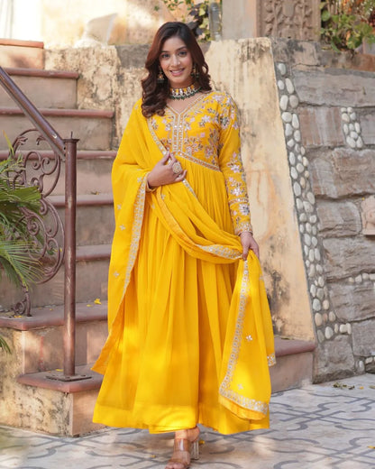 Woman in a yellow traditional outfit standing outdoors.