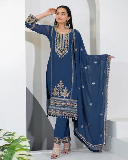 Woman wearing a blue embroidered traditional outfit with a white background
