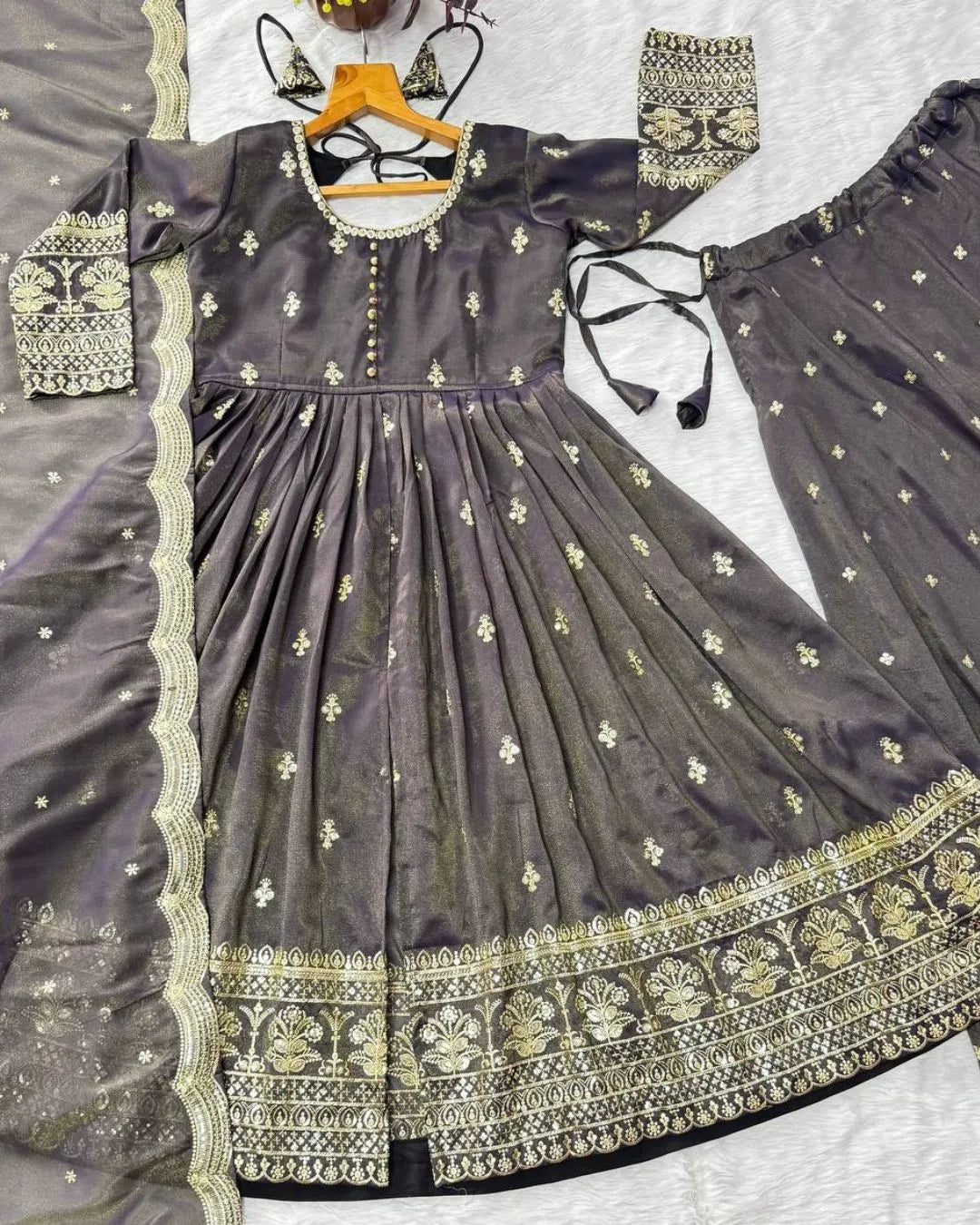 Gray traditional outfit with intricate gold embroidery on a white background