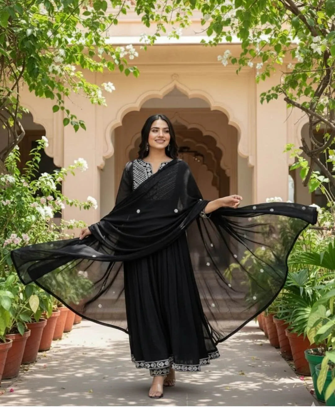 Woman in a Black Cotton Kurti Pant Dupatta Set traditional outfit with a flowing dupatta in a garden setting