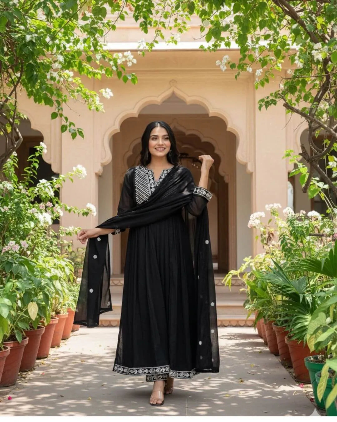 Woman in a Black Cotton Kurti Pant Dupatta Set traditional outfit with a flowing dupatta in a garden setting
