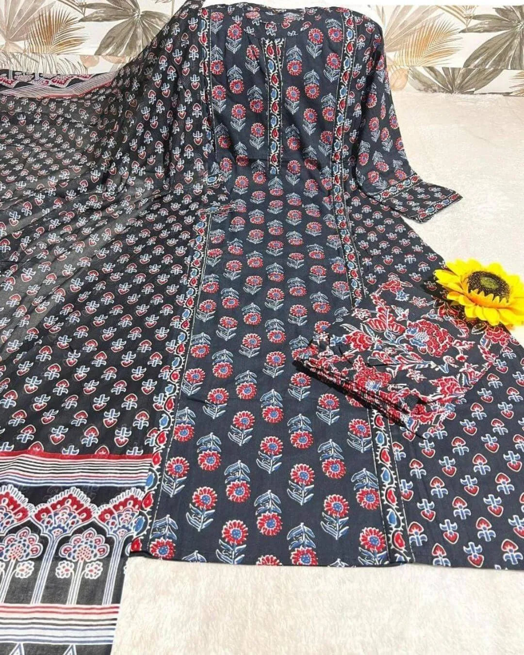 Woman wearing a black Anarkali kurti pant dupatta set standing in a bright room