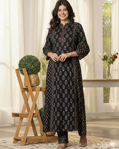 Woman wearing a black Anarkali kurti pant dupatta set standing in a bright room