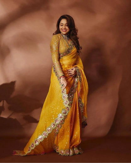 Woman in a yellow saree with intricate designs